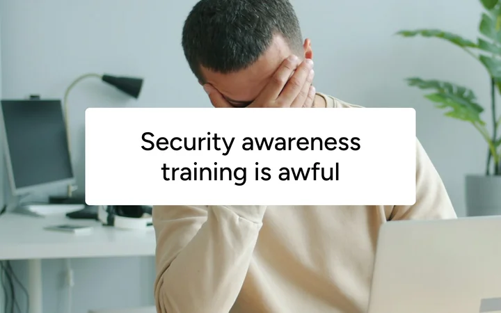 A man covering his face at his desk, captioned 'Security awareness training is awful'.